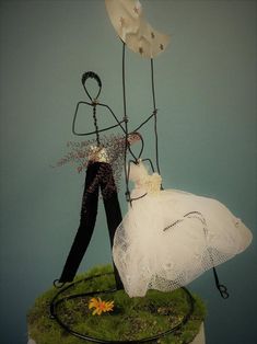 a wedding cake topper with two brides on it and one is holding balloons