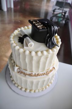 a graduation cake with white frosting and black decorations