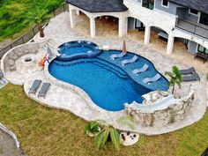 an aerial view of a swimming pool with lounge chairs