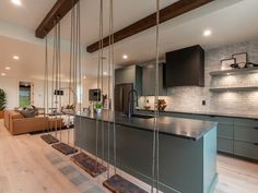 a kitchen and living room are shown in this modern style home with wood flooring