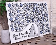 a wedding card with the bride and groom under a tree on top of a table