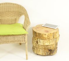 a wooden table with a tablet on top of it next to a wicker chair