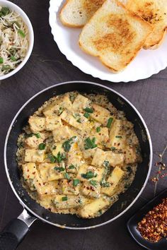 a pan filled with food next to some bread