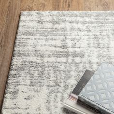 a book is laying on the floor next to an area rug that looks like it has been made out of wood