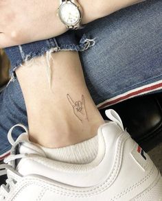 a woman's foot with a small tattoo on it