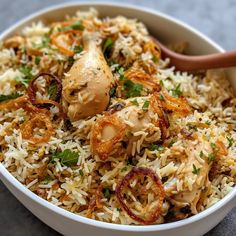 a close up of a bowl of food with rice and meat on it, including onions