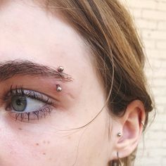 a woman with piercings on her forehead