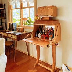 a wooden desk with bottles on it in front of a window