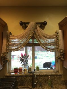 the kitchen window is decorated with flowers and beaded curtains, along with other decorations