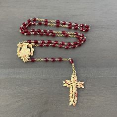 🙏🏻Handmade rosary.  🙏🏻Ruby red color faceted glass beads. 🙏🏻Gold tone pewter crucifix.  🙏🏻Gold tone Madonna and child center medallion. 🙏🏻Gold filled chain. 🙏🏻20 in/50.80 cm in length. 🙏🏻5 decade rosary made using the more traditional method of simple wire loop connections. This type of loop in loop connecting of beads is referred to  as a rosary chain. 🙏🏻The rosary is a Catholic sequence of prayers  that Mary, the Mother of Jesus, asked us to pray and a meditation on the mysteries of Jesus' life. The prayers are performed on a  string of beads used to count each prayer. 🙏🏻Link below to view all rosaries in my shop. https://www.etsy.com/shop/HisHandsJewerly?section_id=35810017 🙏🏻This rosary comes with a white protective pouch. Spiritual Red Crucifix Rosary, Red Rosary Beads For Jewelry Making, Faceted Beads Crucifix Rosary As Gift, Handmade Red Rosary With Cross, Handmade Red Cross Rosary, Handmade Red Rosary, Red Crucifix Rosary As Gift, Mary The Mother Of Jesus, Ruby Red Color