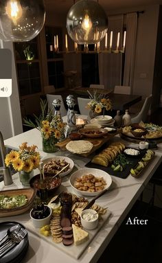 a table filled with lots of food on top of a white counter topped with plates and bowls