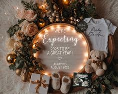 a baby announcement surrounded by christmas decorations and teddy bears on a fur rug with lights