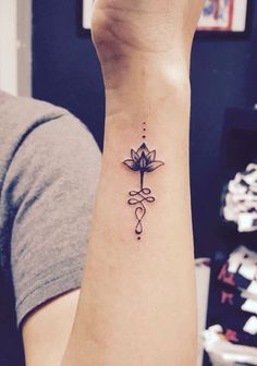 a woman's wrist with a lotus tattoo on it