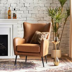 a brown chair sitting in front of a fireplace next to a potted palm tree