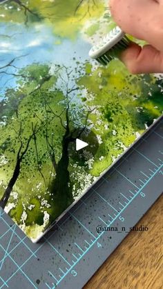 someone is using a brush to paint trees