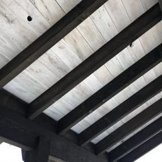 the underside of a wooden roof with exposed beams