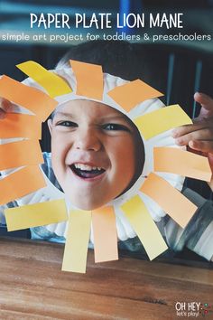 a young boy is making a paper plate lion mane with yellow and orange strips on it