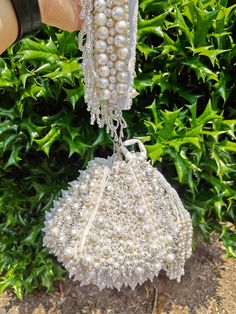 "Premium Quality Heavy Pearl Beaded Handmade  Wedding Lotus Potli/ Bag Purse, White Beaded Bag, White Beaded Clutch The potli/ purse has beautiful beadwork. The purse is made of faux suede and heavily beaded with peal beads all over. The team of artisans has done a fantastic job. These bags/ potlis are ideal for wedding functions, but you can also have them daily. These are ideal for parties, receptions, and gifts. These are small fancy bags designed for putting money, coins, and make-up touch-u Pearl White Beaded Evening Bag For Party, White Beaded Party Bags, White Beaded Potli Bag For Party, White Pearl Embroidered Potli Bag For Evening, White Pearl Embroidery Potli Bag For Evening, Elegant White Potli Bag With Pearl Handle, White Pearl Embroidered Potli Bag For Party, White Bags With Pearl Embroidery For Celebration, White Embellished Pouch Evening Bag