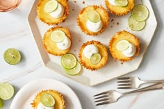 small desserts with lime slices and whipped cream on them sitting on a white plate