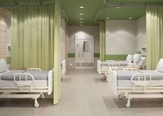 a hospital room with four beds and green drapes on the walls, two are empty