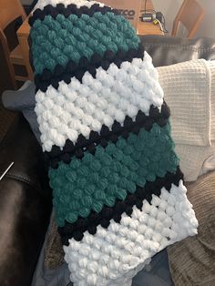 a crocheted blanket sitting on top of a couch