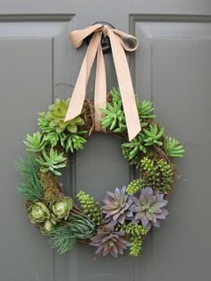 a wreath with succulents hanging on a door