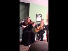 two women are playing guitars in the living room