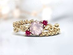 a gold ring with pink and red stones