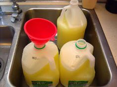 three gallon jugs of liquid sitting in a sink