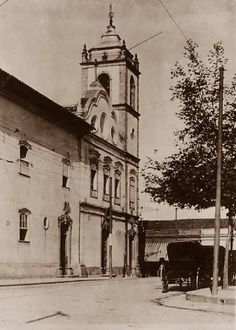 an old black and white photo of a church with a horse drawn carriage in front