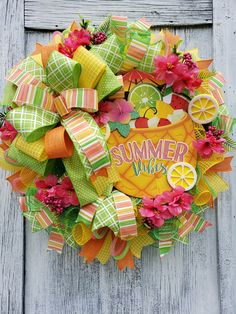 a colorful wreath with the words summer vibes on it sitting on a wooden door