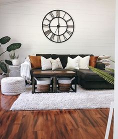 a living room filled with furniture and a large clock on the wall above it's head