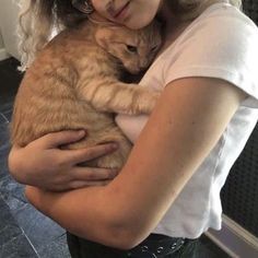 a woman holding a cat in her arms