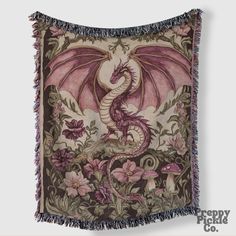 a tapestry with a dragon on it and flowers around the edges, hanging from a wall