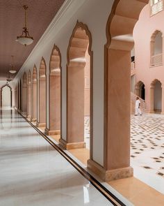 an empty hallway with columns and tiled floor