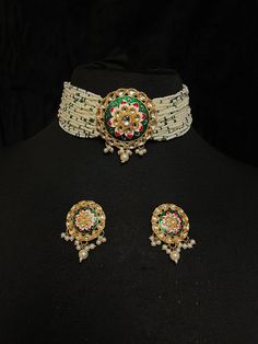 Indian Ladies' Pearl Choker & Earrings of Kundan & Green Meenakari Work Contemporary Indian bridal set with multilayered pearl strands choker and studded earrings. This bridal choker jewelry set is accented with green meenakari pendant and Kundan gemstones making it one of a kind. Gold plated choker with cluster pearls drops adorns this bridal necklace.  This modern choker is sure to make you feel like a million bucks with its elaborating multiple pearl strands in a handcrafted design. This shor Luxury Meenakari Pearl Earrings For Wedding, Kundan Meenakari Choker, Round Meenakari Choker For Celebrations, Meenakari Kundan Choker, Round Meenakari Choker As Gift, Meenakari Choker As Gift, White Meenakari Temple Jewelry Choker, Green Cutdana Choker Jewelry, White Meenakari Choker For Festivals