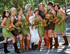 a group of women standing next to each other on a wooden bridge holding bouquets