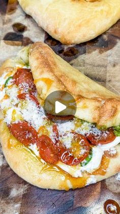 two pizzas sitting on top of a table covered in cheese and tomato toppings