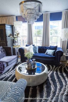 a living room filled with furniture and a chandelier hanging over the top of it