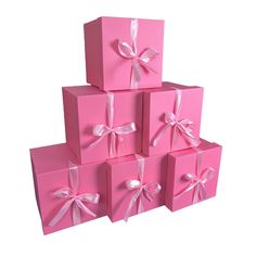 pink gift boxes with white ribbons and bows are stacked on top of each other in the shape of a pyramid