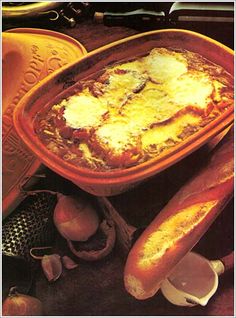 an image of a casserole dish with bread and onions on the table next to it