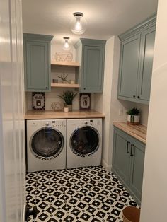 a washer and dryer in a small room with blue cabinets on the walls