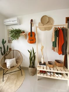 a room with a guitar, potted plant and other items on the shelves in it