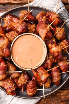 bacon wrapped in toothpicks with dipping sauce on the side, ready to be eaten