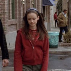 two people walking down the street in front of some buildings