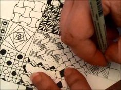 a person is drawing designs on paper with markers