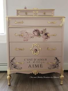 a pink and gold dresser with flowers painted on it