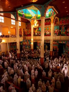 a large group of people standing inside of a church