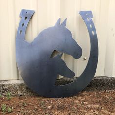 a metal horse head mounted to the side of a building