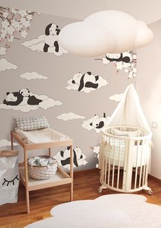 a baby's room with a crib and clouds painted on the wall behind it